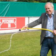 MP Sir Robert Syms watering the pitch at Poole Town.