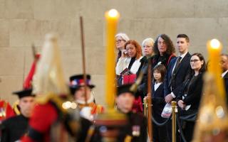 Members of the public file past the coffin of Queen Elizabeth II, draped in the Royal Standard with the Imperial State Crown and the Sovereign’s orb and sceptre, lying in state on the catafalque in Westminster Hall (Reuters via Beat Media Group)